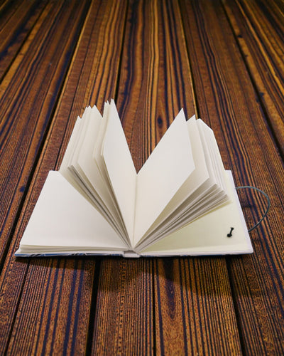 Bølger sammen – lille notesbog med rem og kokosknap 18 × 12,5 cm, 200 sider